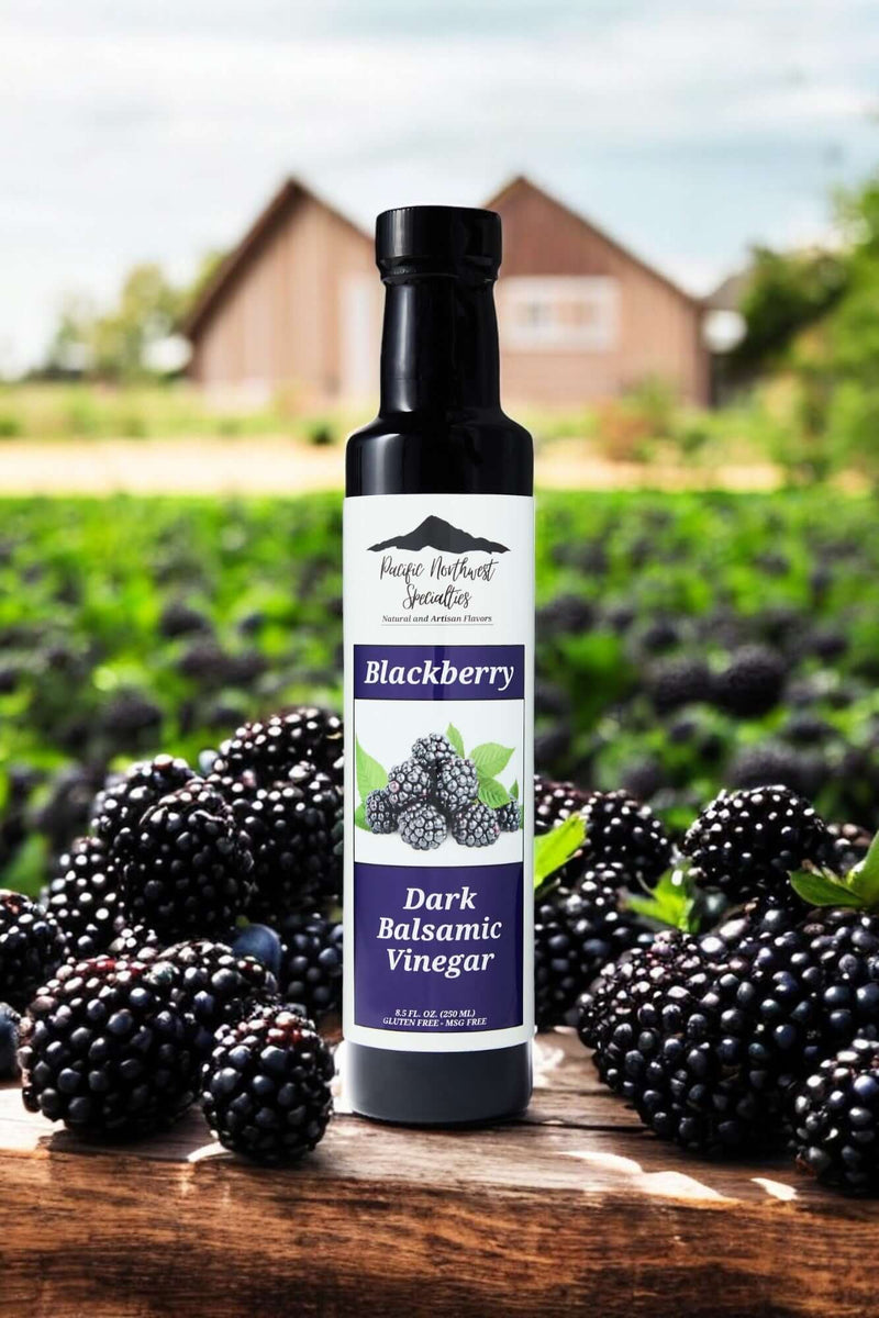 Bottle of Blackberry Dark Balsamic Vinegar surrounded by fresh blackberries on a farm.