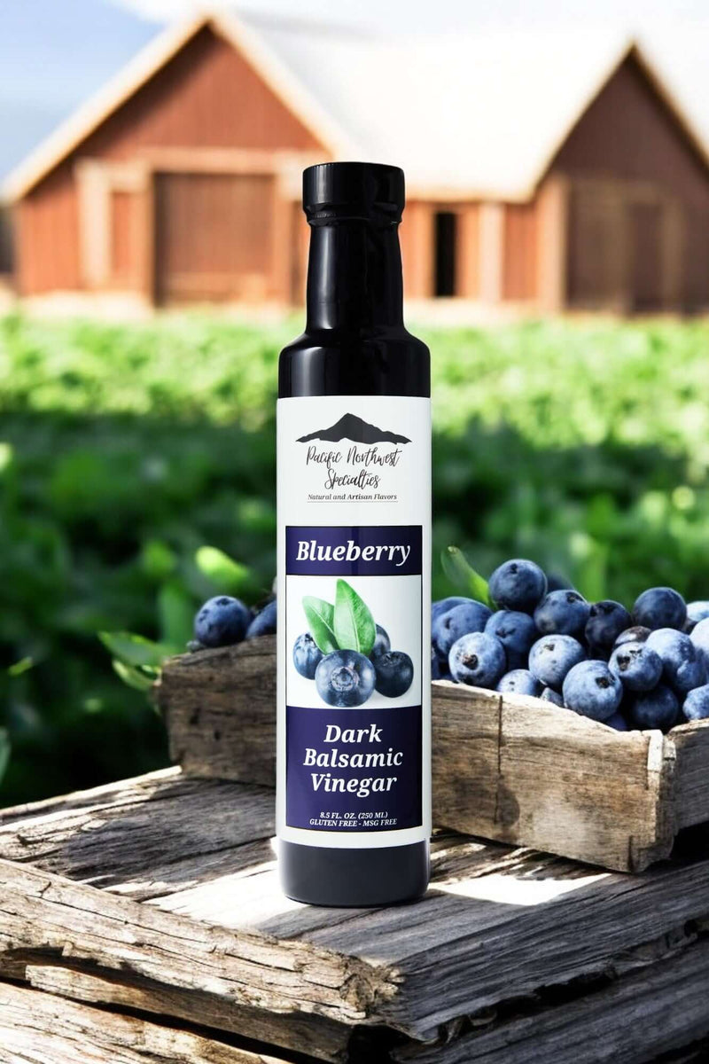 Blueberry Dark Balsamic Vinegar bottle in a rustic setting with fresh blueberries in wooden crate.