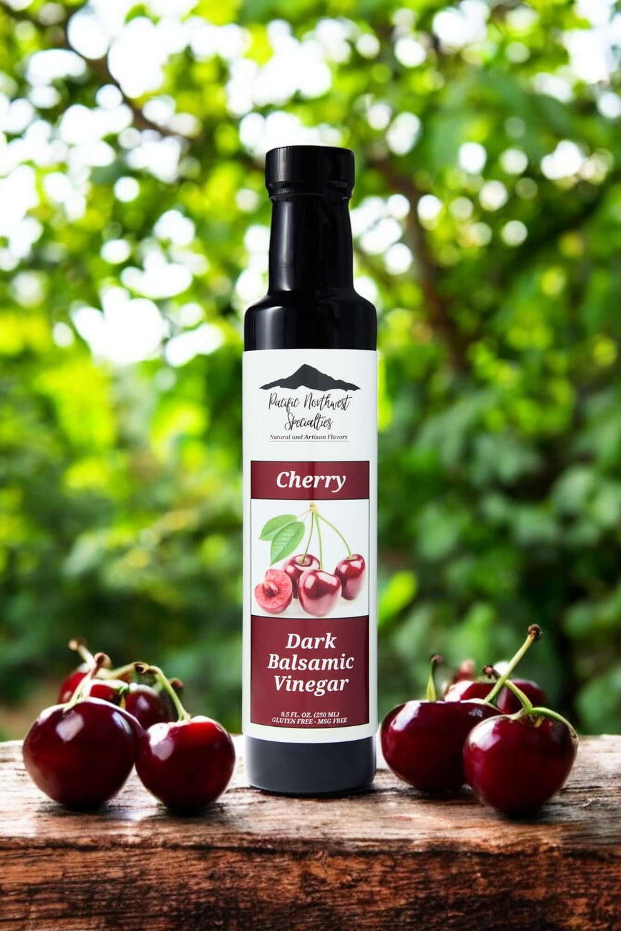 Bordeaux Cherry Dark Balsamic Vinegar bottle on wooden surface with cherries and green background