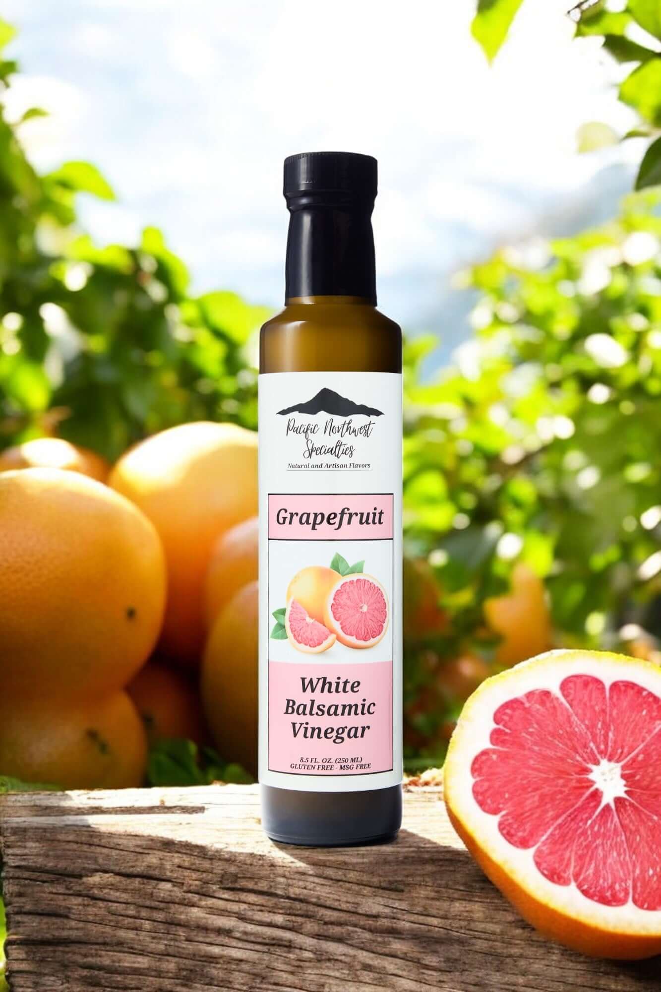Grapefruit White Balsamic vinegar bottle surrounded by fresh grapefruits in a vibrant outdoor setting.