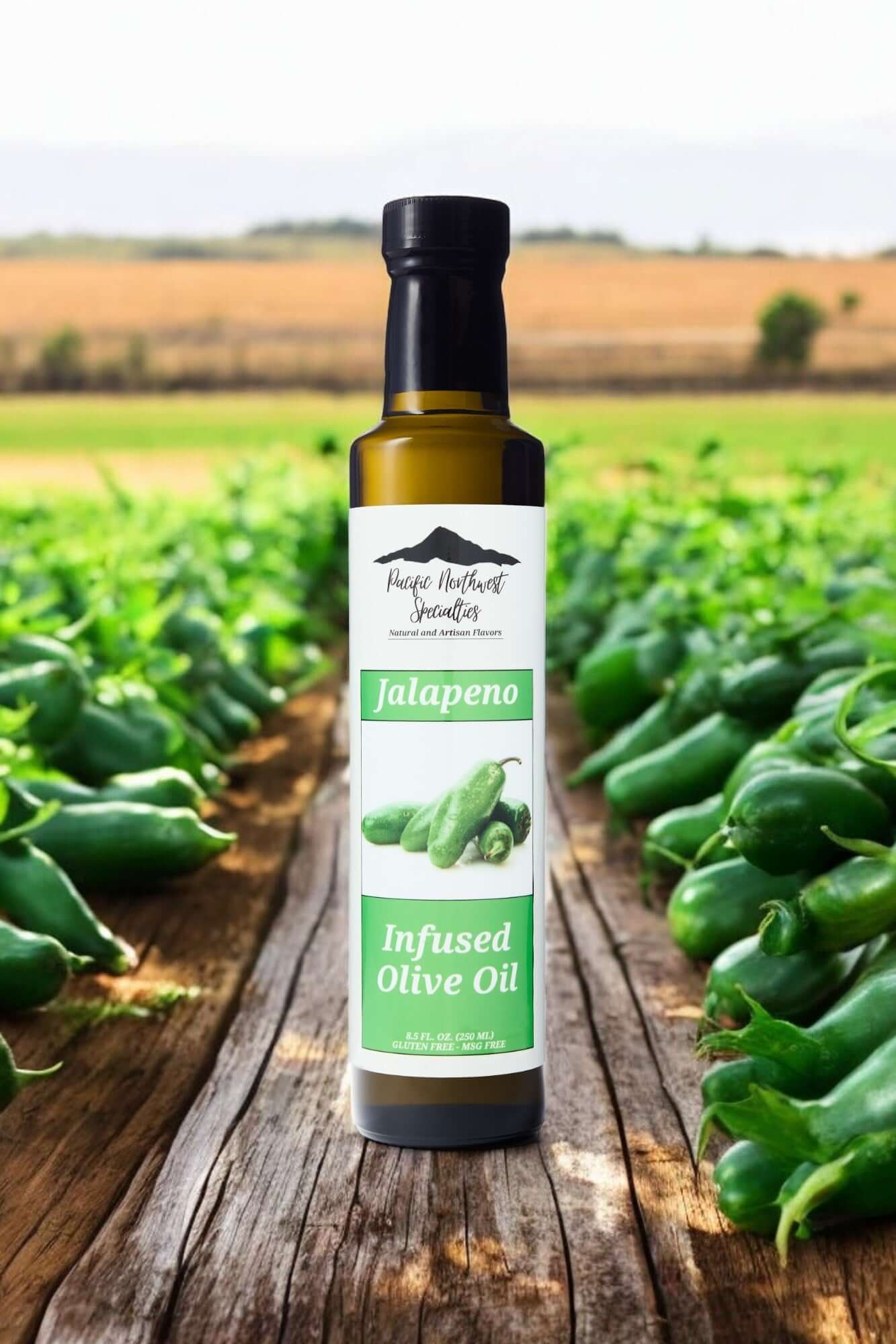 Jalapeno infused olive oil bottle surrounded by fresh jalapeno peppers in a field backdrop.