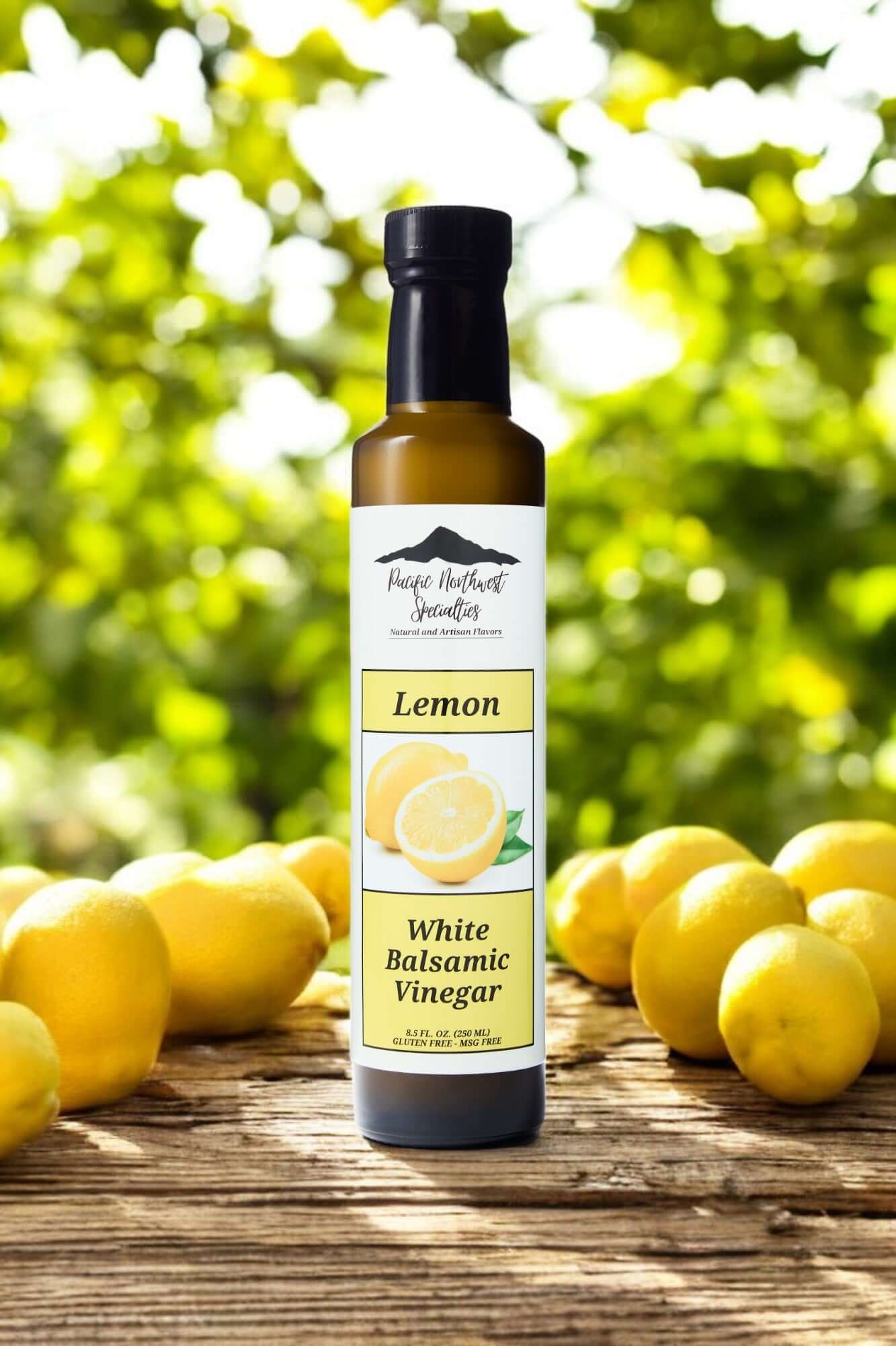 Lemon White Balsamic Vinegar bottle in front of fresh lemons on a bright green background. Perfect for dressings and marinades.