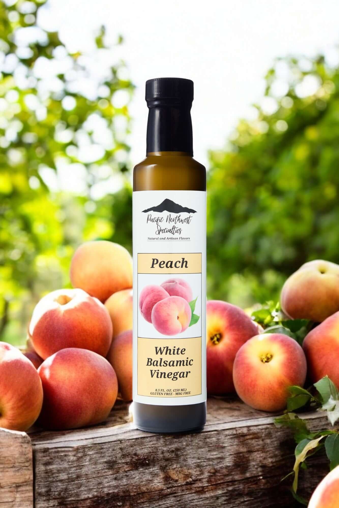 Bottle of Peach White Balsamic Vinegar surrounded by fresh peaches in a natural setting.