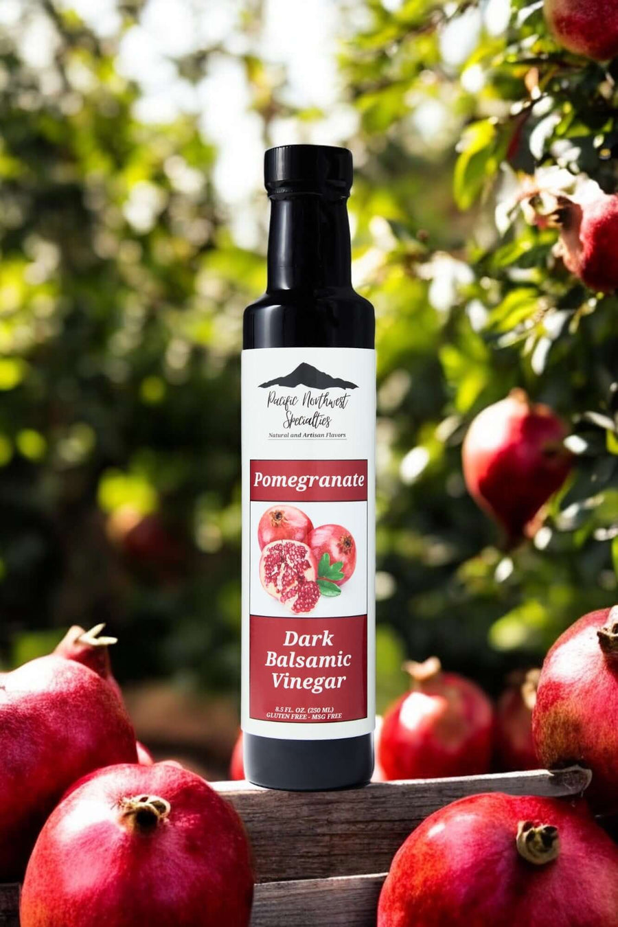 Pomegranate Dark Balsamic Vinegar bottle in an orchard with pomegranate fruits.