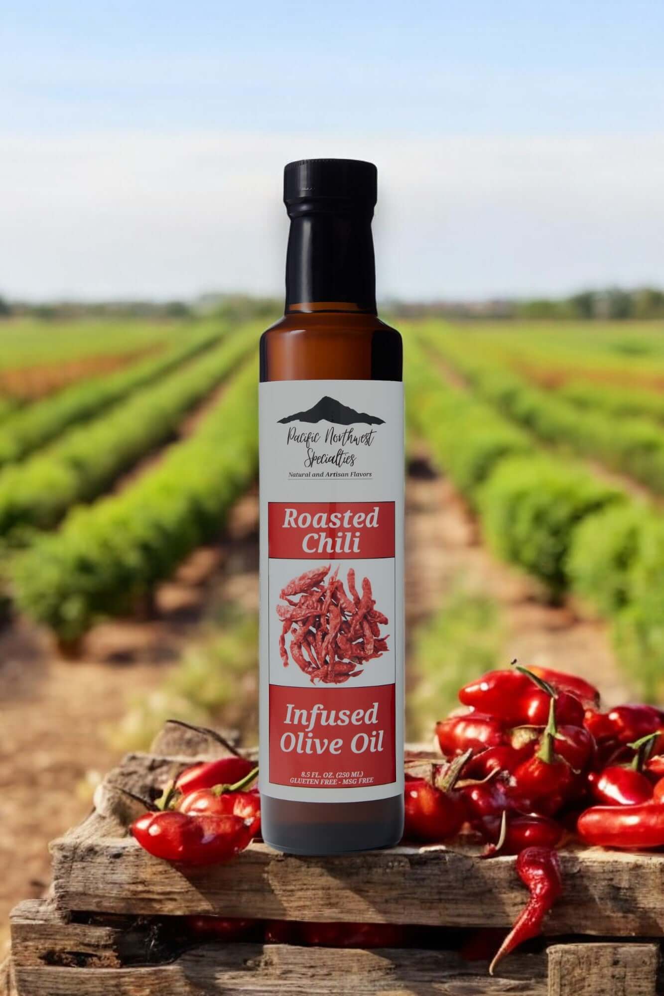 Bottle of Roasted Chili Infused Olive Oil in a vineyard, surrounded by fresh chili peppers.