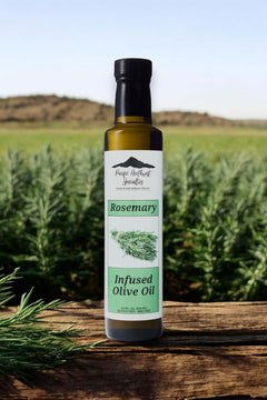 Bottle of rosemary infused olive oil in a field of rosemary plants, perfect for enhancing dishes with rich flavors.